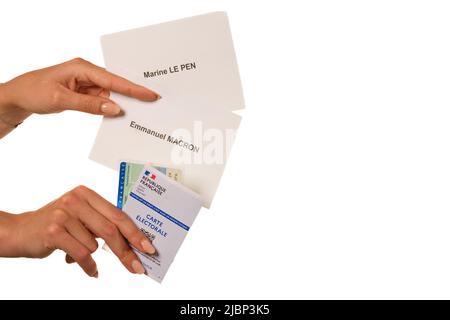 Parigi, Francia - 26 maggio 2022 : una donna che detiene una carta d'identità nazionale, una carta elettorale e schede elettorali per i candidati alle elezioni francesi Foto Stock