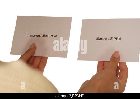 Parigi, Francia - 26 maggio 2022 : una donna che tiene le schede per i candidati alle elezioni francesi Marine le Pen ed Emmanuel Macron Foto Stock