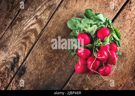 Mazzo di rafano fresco biologico isolato su tavola di legno e sfondo nero vista dall'alto Foto Stock