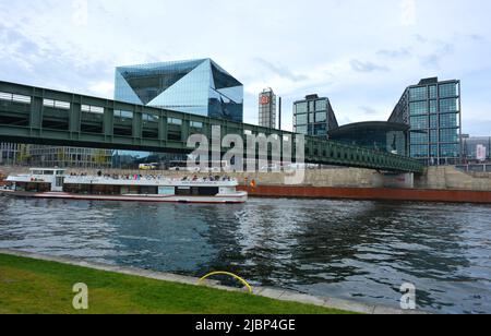 Berlino, Germania 04-20-2022 stazione ferroviaria principale e passerella sul fiume Sprea con barca turistica Foto Stock