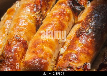 Piffero le salsicce calde sul primo piano della teglia da forno Foto Stock