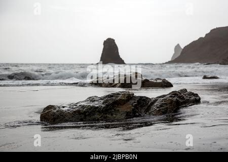 Rocce vulcaniche nere sulla costa dell'oceano. Foto Stock