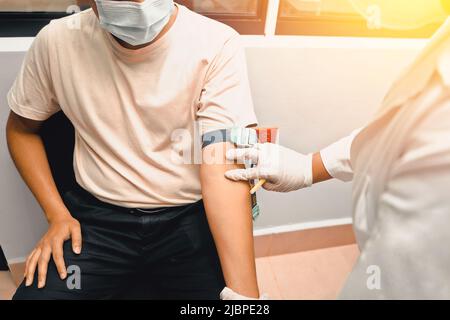 Giovane latino che prende un campione di sangue in un ospedale Foto Stock