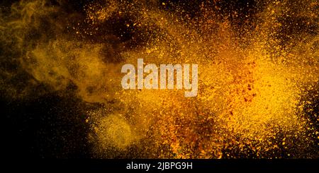 Esplosione, schizzi di curcuma su sfondo nero. India Seasoning. La polvere arancione della radice curmerica. Foto Stock