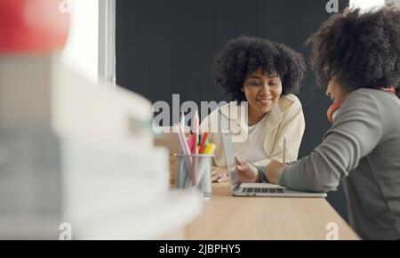 Classe con diversi studenti di studenti felicemente afroamericani e insegnanti che svolgono attività insieme. L'insegnante sta insegnando, guidando e talki Foto Stock