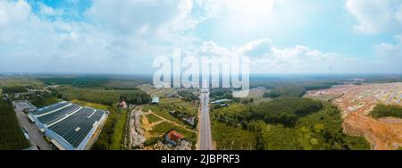 Veduta panoramica aerea della strada Nazionale 14 nella provincia di Binh Phuoc, Vietnam con paesaggio collinare e popolazione sparsa intorno alle strade. Viaggio e terra Foto Stock