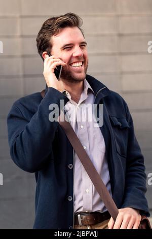 sorridente uomo d'affari caucasico che parla al telefono Foto Stock