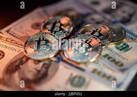 Monete metalliche lucide bitcoin cripto valuta su banconote in dollari statunitensi. Concetto di moneta decentralizzata elettronica. Foto Stock