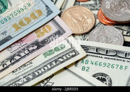 Banconote in dollari USA con numeri di denominazione brillanti, banconote accanto alle monete in dollari, monete da 1 dollari e mezzo dollaro Foto Stock