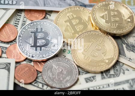 Argento e oro Bitcoin su banconote e monete in dollari. Valuta cripto digitale con fatture e penny in dollari statunitensi. Trading BTC con USD Foto Stock