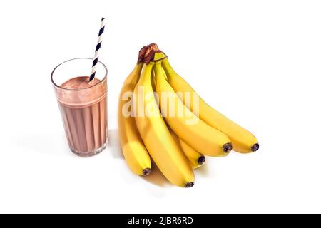 Cioccolato frullato di banane in un bicchiere con cannucce su sfondo bianco Foto Stock