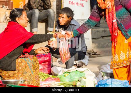 Kathmandu, Nepal - 17 novembre 2018: Donna anziana vende frutta e verdura al mercato di strada Foto Stock