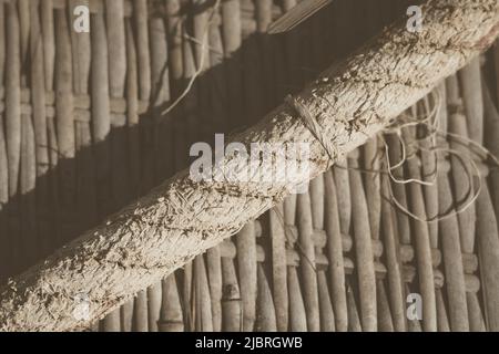 Tappeto di bambù intrecciato vecchio, corda larga tessile ruvida, bordo telaio banner frammento. Linee diagonali, ombra a contrasto. Spazio di copia per il testo. Sfondo astratto Foto Stock