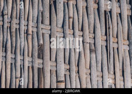 Vecchio tappeto di bambù tessuto, ruvido tessuto sporco, frammento banner. Linee verticali orizzontali diagonali, ombra a contrasto. Spazio di copia per il testo. Astratto Foto Stock