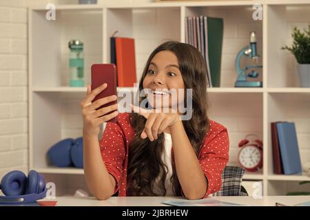 stupito ragazza teen facendo video puntando dito su selfie utilizzando il telefono cellulare, content maker Foto Stock