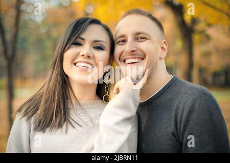 Ritratto all'aperto di coppia interetnica felice nel parco autunnale Foto Stock