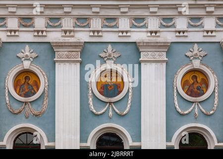 Un frammento del muro di una chiesa ortodossa con icone rotonde e un modello stucco. Foto Stock