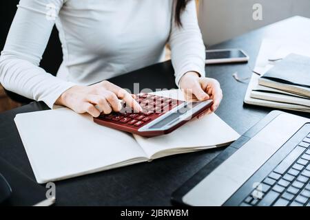 Formule contabili equazioni per i contabili. Contabile femminile che lavora con calcolatrice e laptop Foto Stock