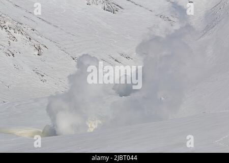 Il vapore sorge dalle fumarole sul vulcano attivo in un paesaggio invernale innevato Foto Stock