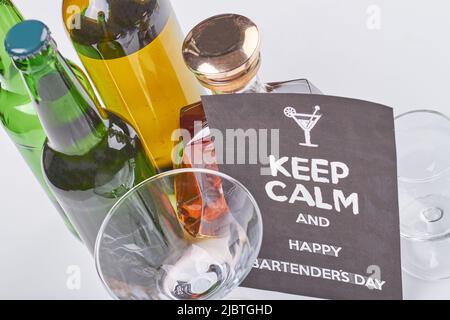 Mantenere calmo e felice giorno baristi. Molte bottiglie di alcol su sfondo bianco. Bevande alcoliche con vista dall'alto. Foto Stock