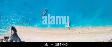 Direttamente sopra la vista della spiaggia di egrenni sull'isola di Lefkada, Grecia copia spazio piccola nave da crociera Foto Stock