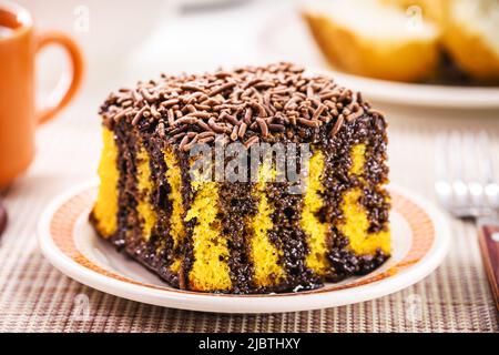 Fetta di torta di carote con crema di cioccolato e spolverini, tipico dei festival brasiliani di giugno, torta fatta in casa Foto Stock