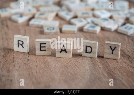 la parola pronta scritta con lettere cubiche su sfondo di legno Foto Stock