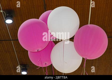 Palloni riempiti di elio viola e bianco in Hall Foto Stock