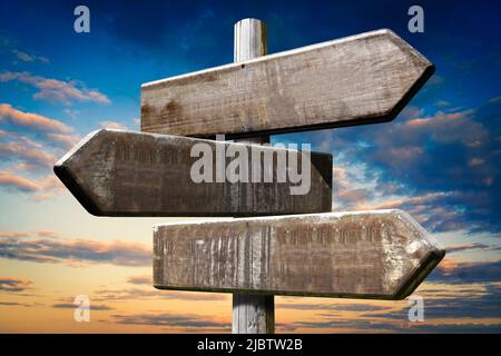 Cartello incrocio in legno con tre frecce Foto Stock