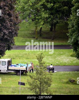 Manchester, Regno Unito, 8th giugno 2022. Vista dall'alto. Un addetto alla raccolta rifiuti raccoglie rifiuti nell'Ardwick Green Park, di proprietà del Manchester City Council, Inghilterra, Regno Unito, Isole britanniche. Fornitura di servizi da parte delle amministrazioni locali. I tre sindacati del governo locale, Unite, UNISON e GMB, hanno presentato una richiesta di retribuzione per il personale in Inghilterra, Galles e Irlanda del Nord per ricevere un aumento di retribuzione di £2.000 ciascuno o il tasso attuale di RPI (attualmente 11,1%), a seconda di quale sia più alto per ciascun individuo. Credit: Terry Waller/Alamy Live News Foto Stock