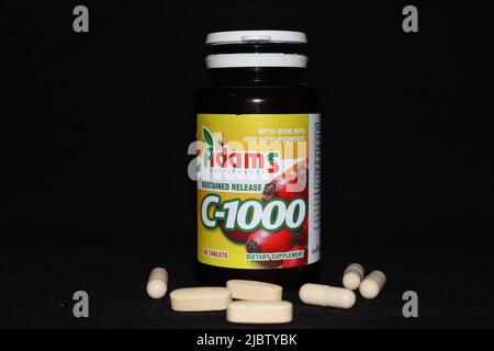 Illustrazione in cui sono presentate alcune vitamine C-1000 dalla società Adams su uno sfondo nero Foto Stock