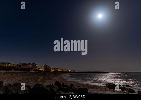 Località balneare tranquilla città di Pomorie con luci elettriche luminose e grandi e confortevoli hotel di lusso sullo sfondo di notte stellato blu cielo e ca Foto Stock