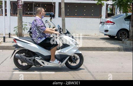 SAMUT PRAKAN, THAILANDIA, Apr 16 2022, un uomo in moto per strada. Foto Stock