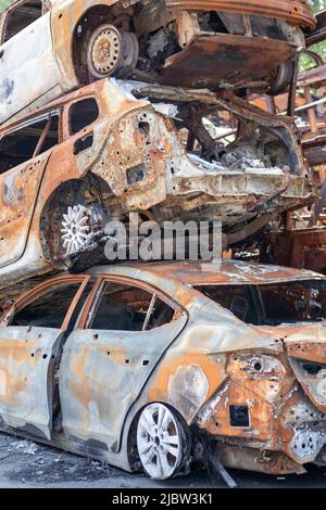 Una visione di auto bruciate dopo gli attacchi dei razzi da parte dell'esercito russo. Guerra della Russia contro l'Ucraina. Veicolo civile dopo l'incendio. Cimitero delle automobili i Foto Stock