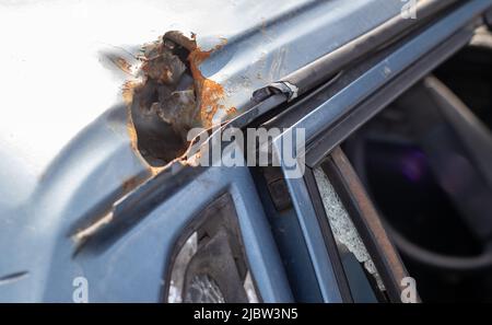 Auto piena di proiettili. Guerra della Russia contro l'Ucraina. Un'auto di civili sparata dall'esercito russo durante l'evacuazione di donne e bambini. Foto Stock