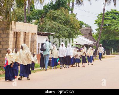 Kizimkazi, Zanzibar - Gennaio 2021: I bambini musulmani tornano dalla scuola sulla strada in un piccolo villaggio di Zanzibar. Tanzania, Africa Foto Stock