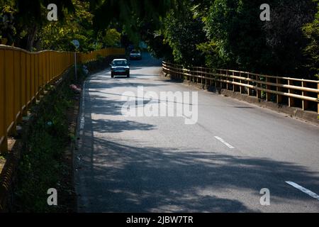 Medellin, Antioquia, Colombia - Gennaio 19 2022: Automobili su una strada asfaltata nel mezzo di una foresta Foto Stock