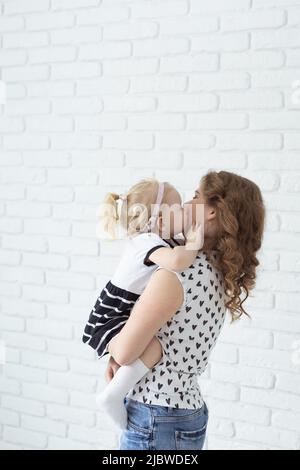 Bambino con impianto cocleare protesi acustica divertirsi con la madre - sordità e diversità concetto. Copia spazio e luogo per la pubblicità Foto Stock