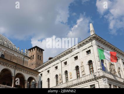 Padova, PD, Italia - 15 maggio 2022: Grande bandiera italiana sul municipio della città e gli antichi palazzi e la torre medievale chiamata Torre degli Anzia Foto Stock