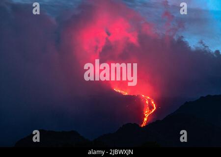 Lava proveniente dal cratere sud-orientale dell'Etna, Sicilia, Italia, vista di notte il 8/6/22. Una nuova fessura si è aperta in questo cratere all'inizio di maggio 2022 ed è stata continuamente attiva da allora. L'Etna (3357m) è uno dei vulcani più attivi del mondo e il più alto d'Europa Foto Stock