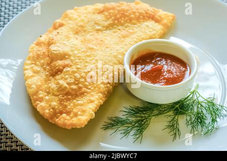 Pastini fatti in casa ripieni di salsa di agnello e pomodoro su un piatto, primo piano Foto Stock