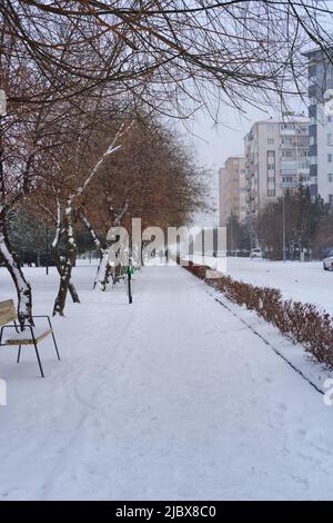 Costruzione e strada sotto la neve in una giornata invernale Foto Stock