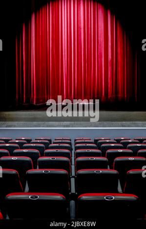 Riflettori luminosi sulle tende del palco nel teatro Foto Stock