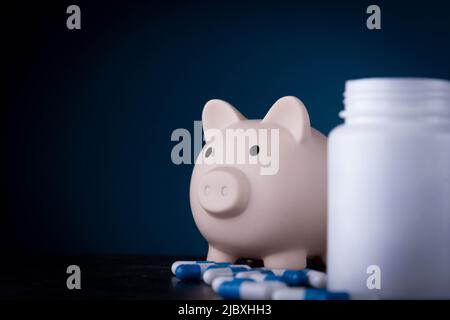 Piggy banca e farmaci. Pillole di acquisto. Credito per il trattamento. Mancanza di fondi per i servizi medici. Foto Stock