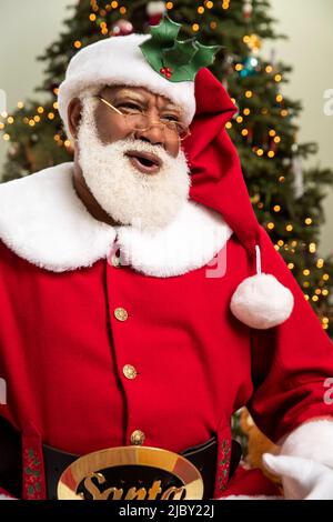 Babbo Natale ridendo e guardando fuori macchina fotografica sullo sfondo di Natale Foto Stock