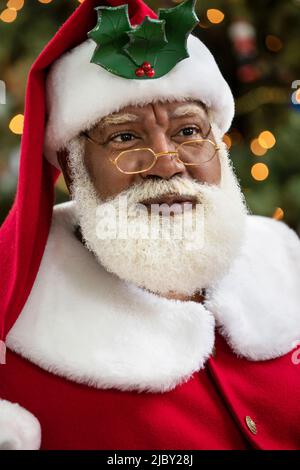 Primo piano ritratto di un anziano uomo nero con barba bianca naturale vestita come Babbo Natale Foto Stock