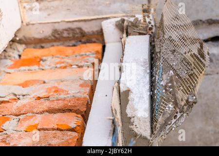 Smantellato isolamento in polistirene e rivestimento della facciata di una casa privata. Rimodellare l'esterno della casa Foto Stock