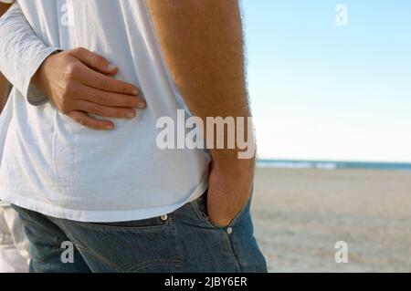 Braccio della donna avvolto intorno alla vita dell'uomo Foto Stock