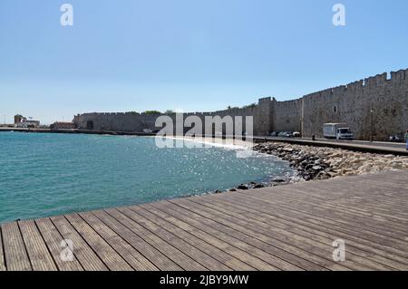 Spiaggia cittadina e passerella in legno. Mura del castello. Città di Rodi, Isola di Rodi, Grecia, Dodecaneso. Maggio 2022. Molla Foto Stock