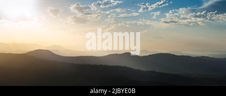 Il sole splende su strati di colline nel tardo pomeriggio preso dall'altopiano di o'Reilly guardando verso la catena divisoria Foto Stock